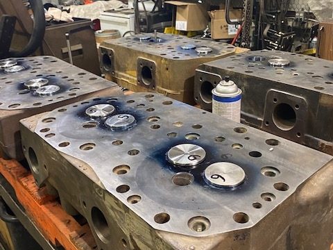 Cat G398 cylinder heads lined up for rebuilding