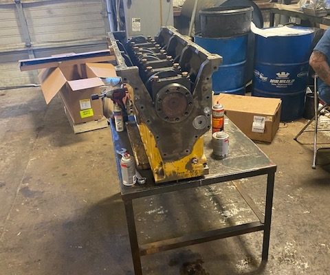 Technician working on a Cat 3306 engine block in the shop